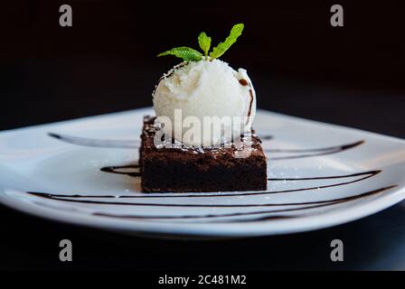 Brownie au chocolat avec crème glacée, sauce au chocolat et garniture à la menthe Banque D'Images