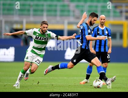 Milan. 25 juin 2020. Domenico Berardi (L) de Sassuolo rivalise avec Roberto Gagliardini (C) du FC Inter lors d'un match de football entre le FC Inter et Sassuolo à Milan, Italie, le 24 juin 2020. Crédit: Xinhua/Alay Live News Banque D'Images