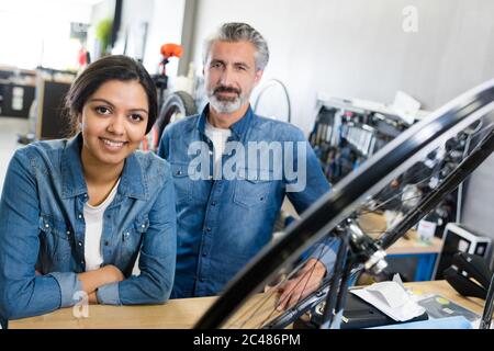 La femme et l'homme comme la mécanique vélo à l'atelier Banque D'Images