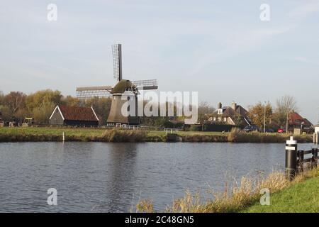 Paysage avec un canal (Noordhollandsch Kanaal) et un moulin à vent (1575) appelé de Sluismolen aux pays-Bas. Novembre. Village de Koedijk. Banque D'Images