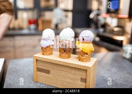 Glace en gaufre au cornet avec différentes saveurs sur le comptoir du magasin, gros plan Banque D'Images