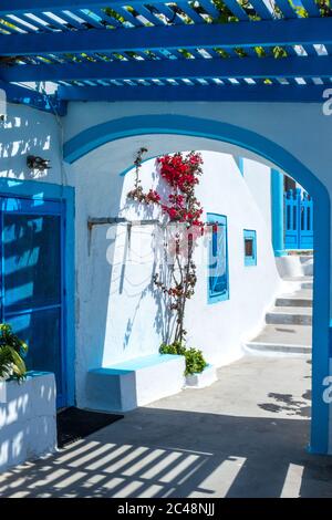 Architecture grecque traditionnelle avec murs blanchis à la chaux et touches bleues, prise dans un village de l'île de Santorini. Banque D'Images