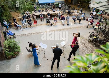 (200625) -- BEIJING, 25 juin 2020 (Xinhua) -- les gens regardent un concert de cour de derrière joué par des membres de l'orchestre de Staatskapelle Berlin à Berlin, capitale de l'Allemagne, le 23 juin 2020. (Photo de Peter Adamik/Xinhua) Banque D'Images