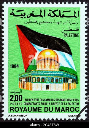 MAROC - VERS 1984 : un timbre imprimé au Maroc montre le drapeau palestinien et le Dôme du Rocher, vers 1984. Banque D'Images