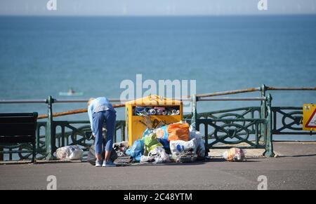 Brighton UK 25 juin 2020 - UN résident local aide à nettoyer la veille de la litière sur le front de mer de Hove , Brighton tôt ce matin, alors que les conditions de la vague de chaleur continuent avec des températures atteignant à nouveau plus de 30 degrés dans certaines parties du Sud-est : Credit Simon Dack / Alamy Live News Banque D'Images