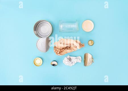 Recyclable différents déchets se composant de papier, verre, métal, plastique sur fond bleu. Concept de séparation des déchets. Mise à plat. Banque D'Images