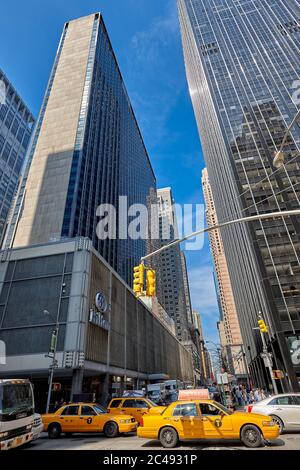 Les taxis à médaillons jaunes se déplacent à l'intersection de la 6e Avenue et de la West 54th Street. Manhattan, New York, États-Unis. Banque D'Images