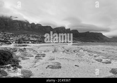 Se dressant sur la plage de camps Bay et regardant les nuages tourbillonnants au-dessus des montagnes des douze Apôtres et de la ville de camps Bay, au Cap. Banque D'Images