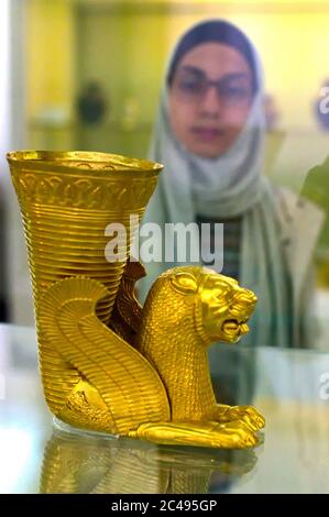 La femme musulmane iranienne admire Achaemenid Perse Lion vase Rhyton monument archéologique du 5e siècle avant Jésus-Christ, Téhéran, Iran Banque D'Images