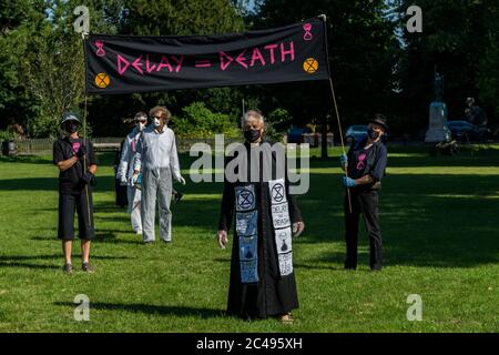 LEOMINSTER, ROYAUME-UNI - 25 JUIN 2020 : les manifestants pour le changement climatique se réunissent dans le cadre d'une journée de manifestations nationales, avec pour objectif l'avertissement « Delay = Death » à Leominster, Herefordshire, Royaume-Uni, le 25 juin 2020. Programmé pour coïncider avec la publication d'un rapport de la Commission parlementaire britannique sur le changement climatique, le cortège sombre composé de personnages costumés portant des costumes de sablier portait un modèle de terre bandé aux portes des députés locaux. Crédit : Jim Wood/Alay Live News Banque D'Images