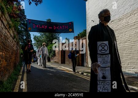 LEOMINSTER, ROYAUME-UNI - 25 JUIN 2020 : les manifestants pour le changement climatique se réunissent dans le cadre d'une journée de manifestations nationales, avec pour objectif l'avertissement « Delay = Death » à Leominster, Herefordshire, Royaume-Uni, le 25 juin 2020. Programmé pour coïncider avec la publication d'un rapport de la Commission parlementaire britannique sur le changement climatique, le cortège sombre composé de personnages costumés portant des costumes de sablier portait un modèle de terre bandé aux portes des députés locaux. Crédit : Jim Wood/Alay Live News Banque D'Images