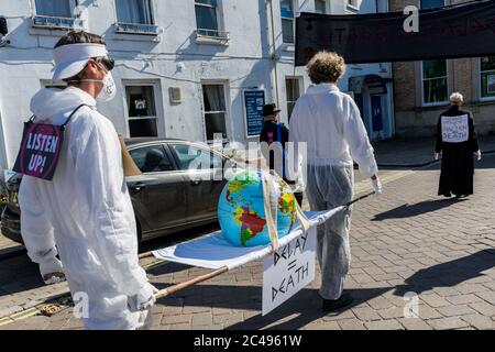 LEOMINSTER, ROYAUME-UNI - 25 JUIN 2020 : les manifestants pour le changement climatique se réunissent dans le cadre d'une journée de manifestations nationales, avec pour objectif l'avertissement « Delay = Death » à Leominster, Herefordshire, Royaume-Uni, le 25 juin 2020. Programmé pour coïncider avec la publication d'un rapport de la Commission parlementaire britannique sur le changement climatique, le cortège sombre composé de personnages costumés portant des costumes de sablier portait un modèle de terre bandé aux portes des députés locaux. Crédit : Jim Wood/Alay Live News Banque D'Images