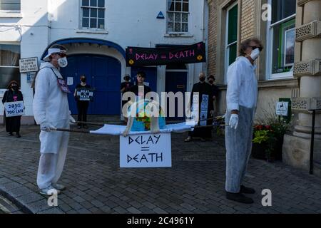 LEOMINSTER, ROYAUME-UNI - 25 JUIN 2020 : les manifestants pour le changement climatique se réunissent dans le cadre d'une journée de manifestations nationales, avec pour objectif l'avertissement « Delay = Death » à Leominster, Herefordshire, Royaume-Uni, le 25 juin 2020. Programmé pour coïncider avec la publication d'un rapport de la Commission parlementaire britannique sur le changement climatique, le cortège sombre composé de personnages costumés portant des costumes de sablier portait un modèle de terre bandé aux portes des députés locaux. Crédit : Jim Wood/Alay Live News Banque D'Images