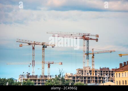 Grues de construction industrielle fonctionnant sur le chantier, développement de bâtiments résidentiels Banque D'Images