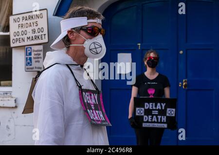 LEOMINSTER, ROYAUME-UNI - 25 JUIN 2020 : les manifestants pour le changement climatique se réunissent dans le cadre d'une journée de manifestations nationales, avec pour objectif l'avertissement « Delay = Death » à Leominster, Herefordshire, Royaume-Uni, le 25 juin 2020. Programmé pour coïncider avec la publication d'un rapport de la Commission parlementaire britannique sur le changement climatique, le cortège sombre composé de personnages costumés portant des costumes de sablier portait un modèle de terre bandé aux portes des députés locaux. Crédit : Jim Wood/Alay Live News Banque D'Images