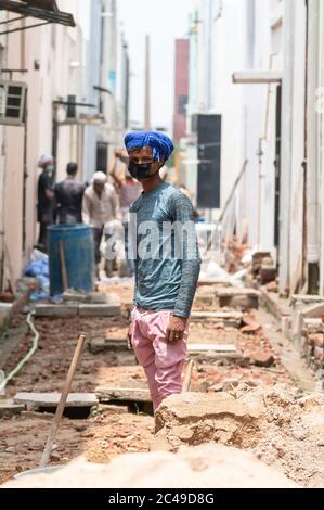 Jeune homme indien travaillant sur le chantier avec masque médical sur son visage pour prévenir de virus et de poussière, Ghaziabad, Inde, juin 2020 Banque D'Images