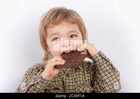 Un joli bébé qui mange du chocolat Banque D'Images