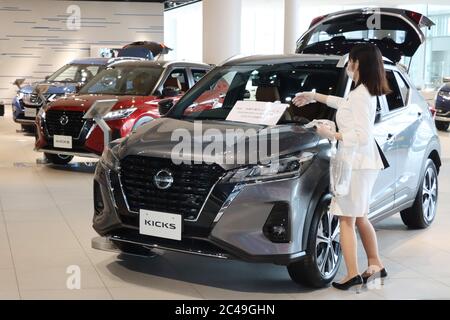 Yokohama, Japon. 25 juin 2020. Un employé du géant automobile japonais Nissan Motor dépoussière le nouveau véhicule multisegment compact « prend » des coups de pied dans la salle d'exposition de la société à Yokohama, banlieue de Tokyo, le jeudi 25 juin 2020. Les baskets sont équipées d'un système d'entraînement e-Power qui comporte un moteur électrique qui entraîne ses roues avant tandis qu'un moteur à essence génère de l'électricité pour le moteur. Crédit: Yoshio Tsunoda/AFLO/Alay Live News Banque D'Images