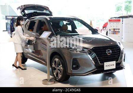 Yokohama, Japon. 25 juin 2020. Un employé du géant automobile japonais Nissan Motor dépoussière le nouveau véhicule multisegment compact « prend » des coups de pied dans la salle d'exposition de la société à Yokohama, banlieue de Tokyo, le jeudi 25 juin 2020. Les baskets sont équipées d'un système d'entraînement e-Power qui comporte un moteur électrique qui entraîne ses roues avant tandis qu'un moteur à essence génère de l'électricité pour le moteur. Crédit: Yoshio Tsunoda/AFLO/Alay Live News Banque D'Images