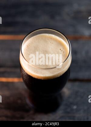 Vue du dessus un verre de bière portier sur une table de pub sombre Banque D'Images