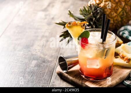 Cocktail de mai tai froid avec ananas et cerise sur une table en bois. Espace de copie Banque D'Images