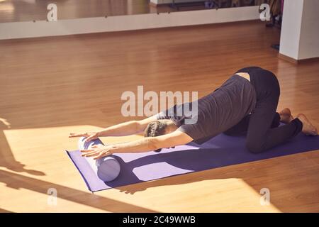 Jeune homme faisant de l'exercice avec bloc de rouleau de yoga Banque D'Images