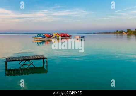 Toile de fond de voyage de pédalos et de kayaks sur les jetées au lac Balaton au coucher du soleil en Hongrie Banque D'Images