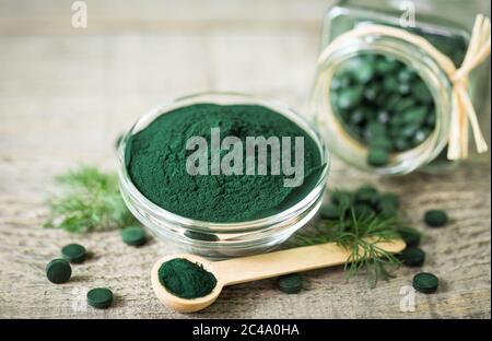 Comprimés de spiruline et poudre dans des bols Banque D'Images