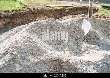 Site de constriction avec une pile de sable de gravier et une pelle coincée en elle. Banque D'Images