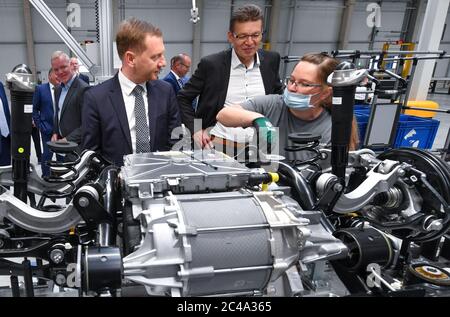 25 juin 2020, Saxe, Meerane: Michael Kretschmer (CDU, l), Premier ministre de Saxe, et Reinhard de Vries, Directeur général de Volkswagen Saxe, parlent à Nicole Schwabe, dans un nouveau hall de production pour la fabrication de systèmes de châssis pour la famille VW ID. Avant cela, la pierre de fondation d'une autre salle a été posée dans le parc industriel de Meerane. Volkswagen Sachsen louera cette salle de 25,000 mètres carrés pour la production des véhicules entièrement électriques de la famille ID. Le promoteur du projet Metawerk prévoit la création d'au moins 2,000 emplois dans le parc industriel d'ici 2022 et ar Banque D'Images