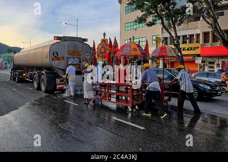 Penang, Malaisie - 8 février 2017 : les dévotés versant de l'eau sur la route avant l'arrivée du char d'argent pendant la veille de Tisipusam.Tisipusam est célébré Banque D'Images