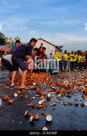 Penang, Malaisie - 8 février 2017 : les dévotés se préparant à l'arrivée du char d'argent en écrasant la noix de coco sur la route et en nettoyant l'équipe préparai Banque D'Images