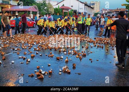 Penang, Malaisie - 8 février 2017. Peu de travailleurs municipaux pour nettoyer la noix de coco sur la route pour dégager le trafic pour le char de Dieu de se déplacer Banque D'Images