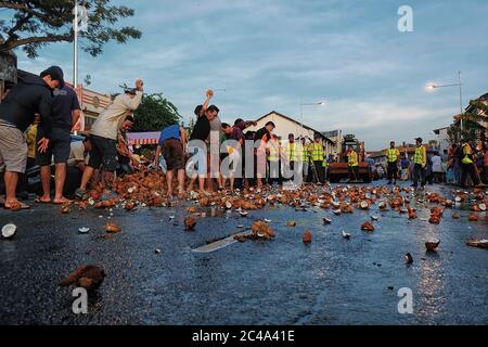 Penang, Malaisie - 8 février 2017. Des dévotés hindous écrasent la noix de coco dans la rue à la veille de Thabousam. Banque D'Images