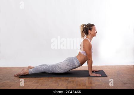 Une jeune femme en yoga pose de l'exercice à la maison Banque D'Images
