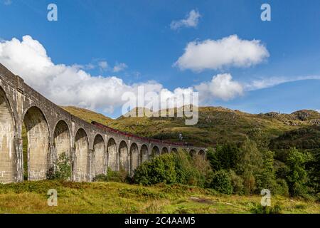 Le viaduc de Glenfinnan dans les Highlands écossais, avec des montagnes verdoyantes et accidentées derrière Banque D'Images