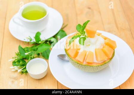 Melon Bingsu avec Lait condensé Sucré sur table en bois Banque D'Images