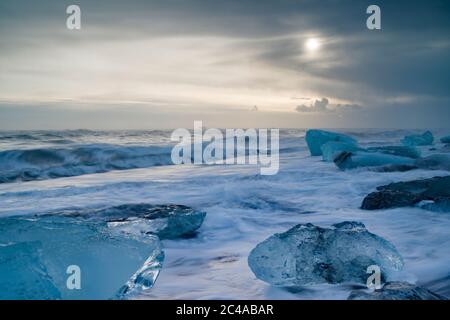 La plage de Jokulsarlon, alias Diamond Beach, est située sur la route côtière A1 sur la côte. Les icebergs - certains sont de grands blocs - réfléchissent la lumière contre un ensemble de sable noir. Banque D'Images