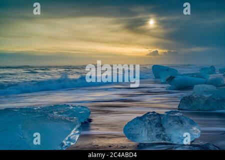 La plage de Jokulsarlon, alias Diamond Beach, est située sur la route côtière A1 sur la côte. Les icebergs - certains sont de grands blocs - réfléchissent la lumière contre un ensemble de sable noir. Banque D'Images