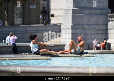 Londres, Royaume-Uni. 25 juin 2020. Météo au Royaume-Uni : les touristes profitent du soleil à Trafalgar Square, sur ce qui devrait être le jour le plus chaud de l'année jusqu'à présent. L'indice UV du bureau met devrait atteindre des niveaux exceptionnellement élevés, en raison du ciel dégagé et de l'absence de pistes de vapeur d'avion en raison d'une réduction des vols pendant la pandémie du coronavirus. Credit: Stephen Chung / Alay Live News Banque D'Images