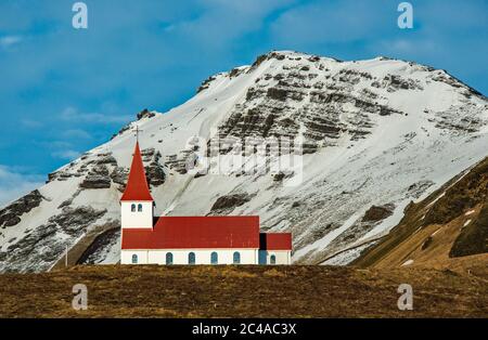 Église de Reyniscyrka au-dessus de la ville côtière de Vik, sur la côte sud de l'Islande, au large de la route côtière A1. Magnifiquement situé en face d'une montagne enneigée Banque D'Images