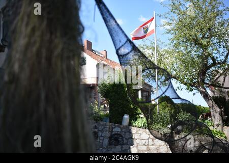 Berlin, Allemagne. 25 juin 2020. Un piège à poisson est suspendu devant le drapeau du quartier de Berlin Treptow-Köpenick dans les locaux du 'Muggelsee-Fischerei'. Credit: Sven Braun/dpa/Alay Live News Banque D'Images