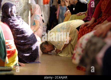 Krishna femme disciple s'agenouillant sur un sol et priant dans un temple Banque D'Images