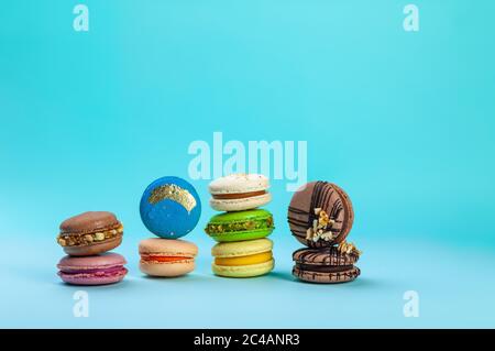 Différents types de desserts colorés doux macarons sur fond bleu Banque D'Images