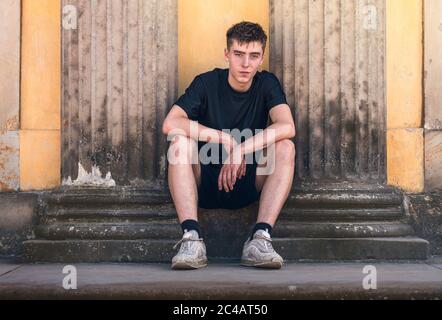 portrait d'un jeune homme assis entre deux piliers anciens Banque D'Images