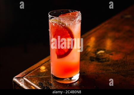 Un cocktail ABV bas orange dans un verre à haute bille rempli de glace et garni d'un morceau d'orange Banque D'Images
