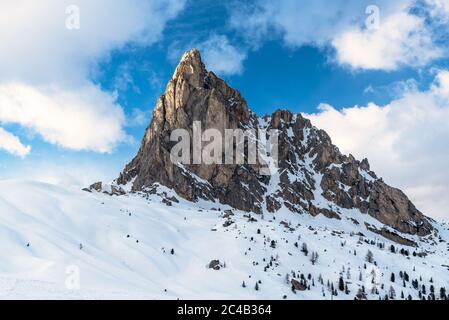 La neige couvrait un sommet impressionnant dans les Dolomites sous un ciel bleu avec des nuages en hiver Banque D'Images