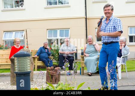 Ardara, Comté de Donegal, Irlande. 25 juin 2020. Le célèbre chanteur Daniel O’Donnell a fait aujourd’hui une visite surprise au St. Shanaghan House abrité Housing dans le village. Il a chanté plusieurs de ses chansons bien connues à l'extérieur du complexe d'appartements à des applaudissements rapaces de résidents, dont beaucoup sont en isolement cellulaire depuis des mois en raison de la pandémie de Covid-19. Daniel O’Donnell est un natif du comté de Donegal né à Dungloe en 1961, ce qui le rend maintenant âgé de 59 ans. Banque D'Images