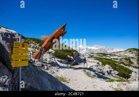 Randonneurs sur le sentier de randonnée circulaire Heilbronn en face de la sculpture de requin Dachstein, derrière elle le Hoher Dachstein, le sentier de randonnée Karst, Krippenste Banque D'Images