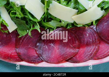 Assiette de bresaola de bœuf séché, salade d'arugula et parmesan Banque D'Images